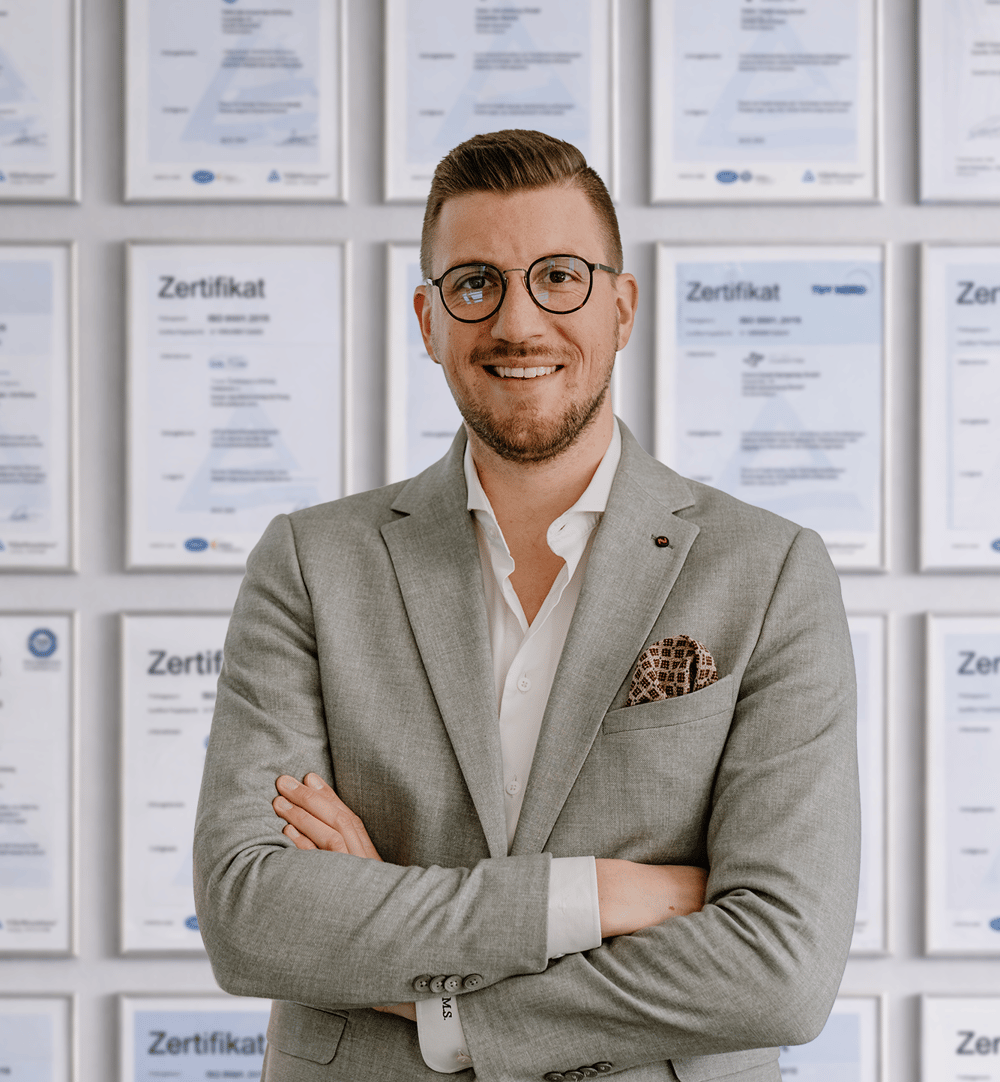 Marcel Spitzel, Senior Auditor, vor der Zertifikatswand des IfDQ